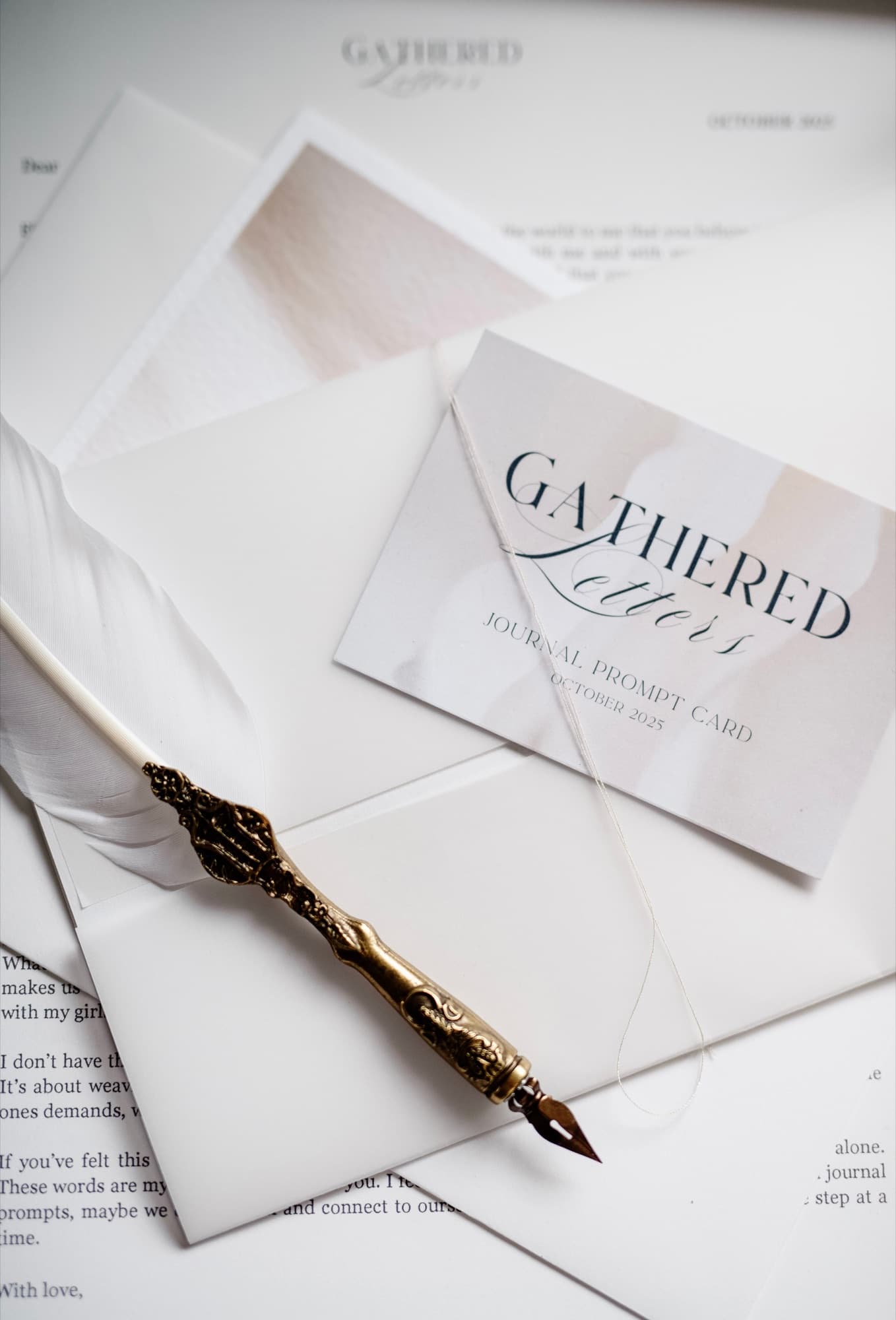 A Gathered Letters envelope and journal prompt card with a gold pen